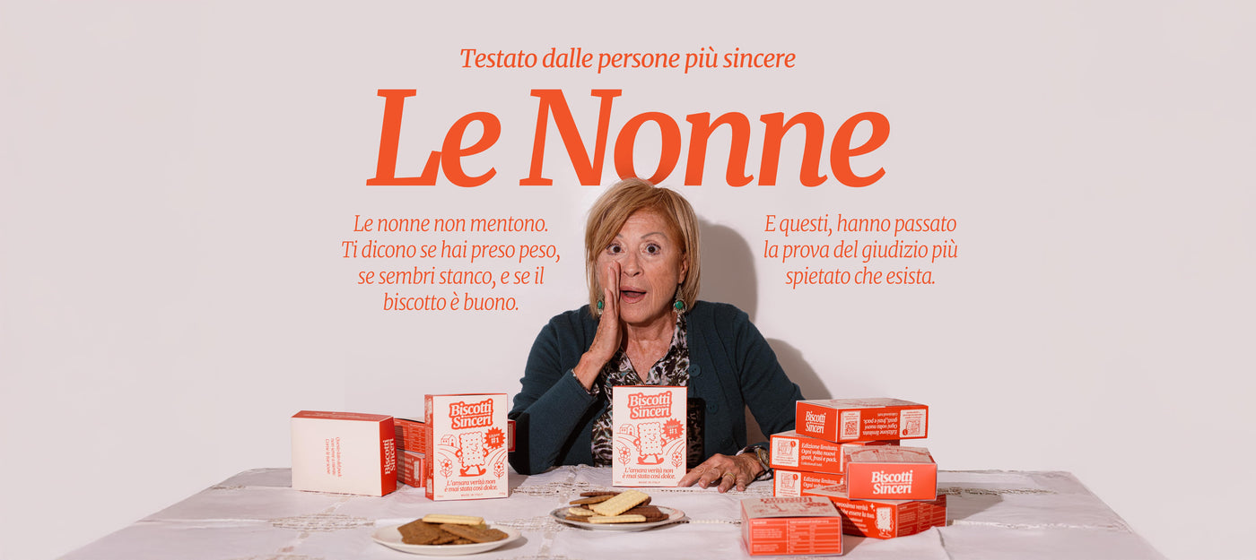 Una nonna dietro un tavolo coperto di confezioni di Biscotti Sinceri